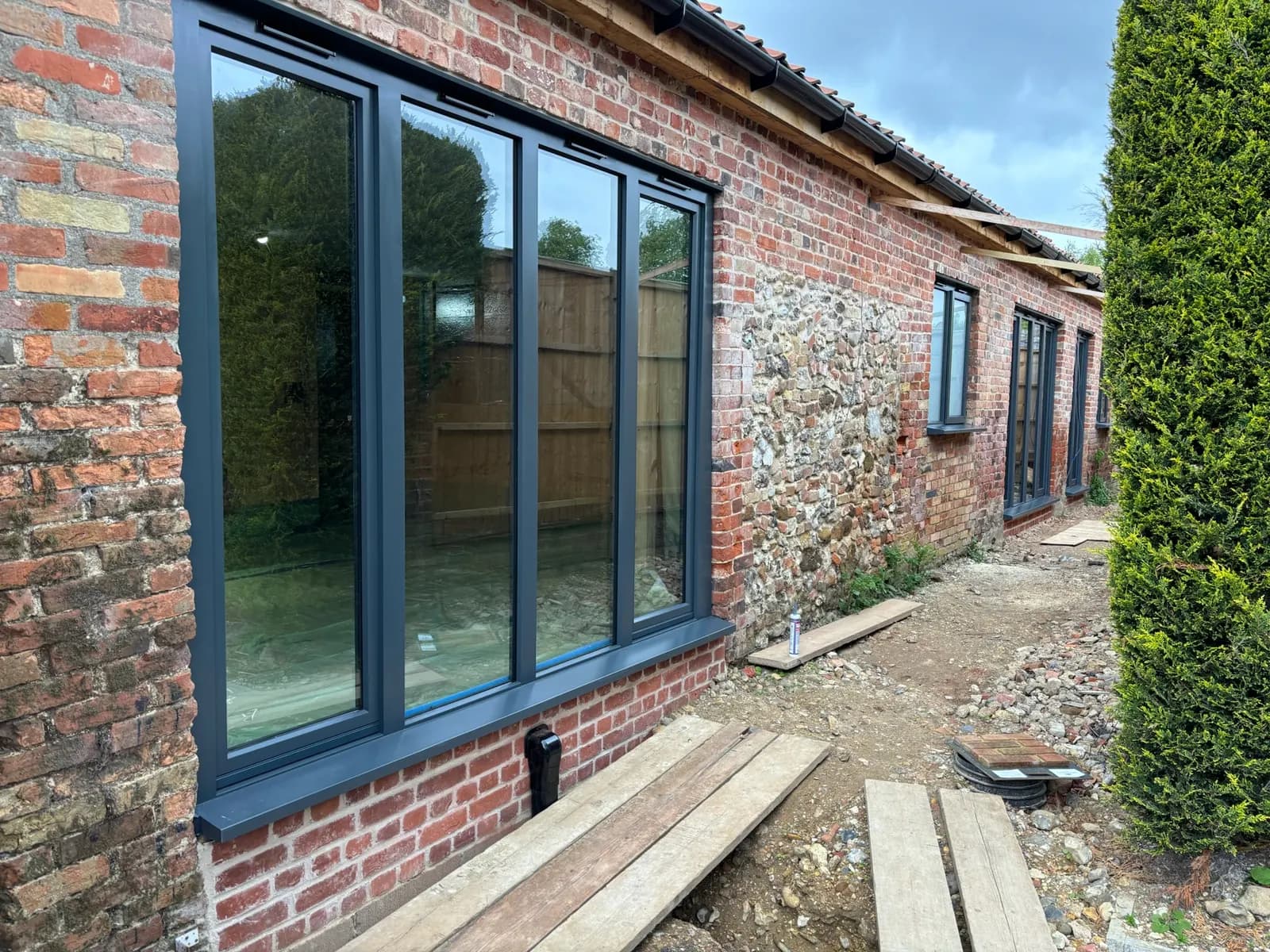 Dark flush windows fitted to a brick-and-flint building